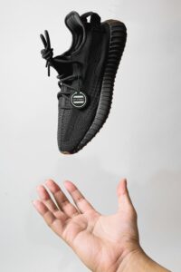 Hand Catching a Black Sneaker Shoe 